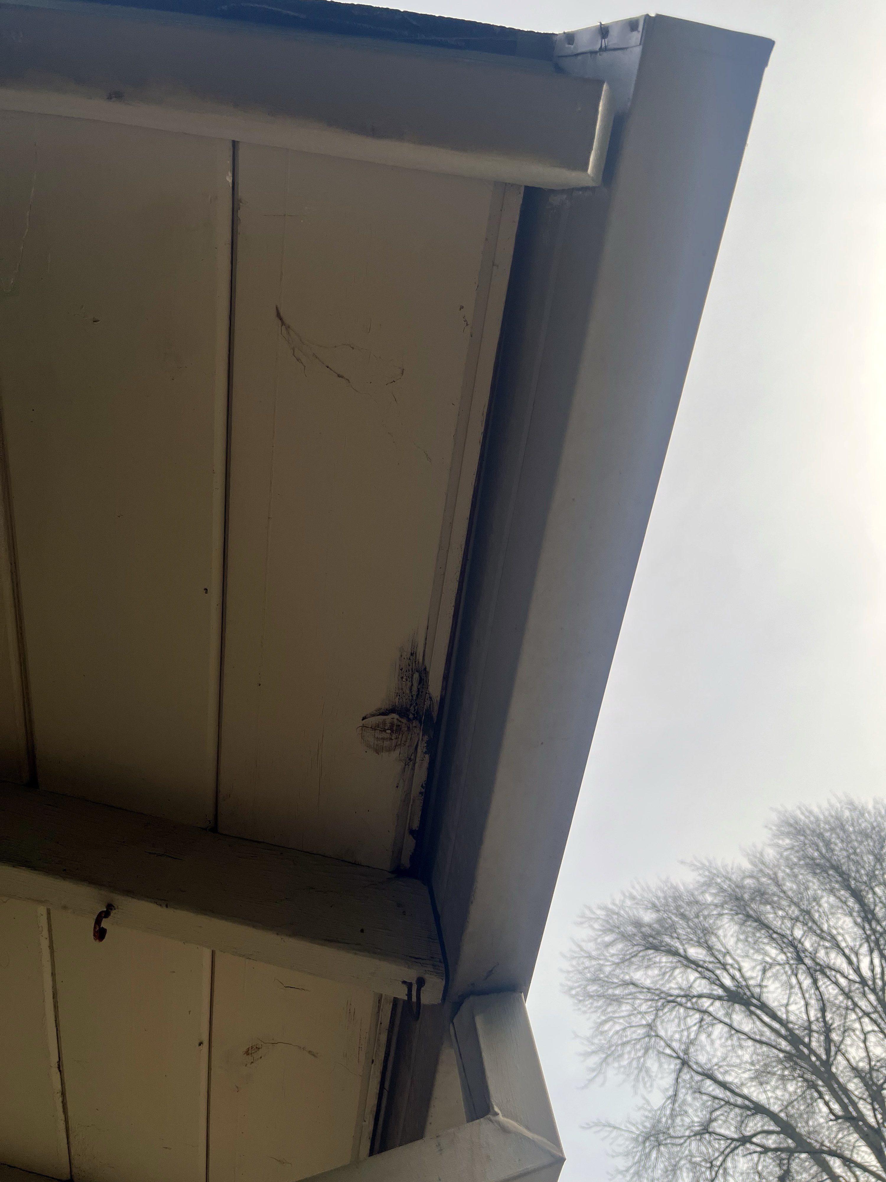 A water intrusion stain on a Northern California home's soffit — overflow from above has reached the building envelope after sustained gutter failure