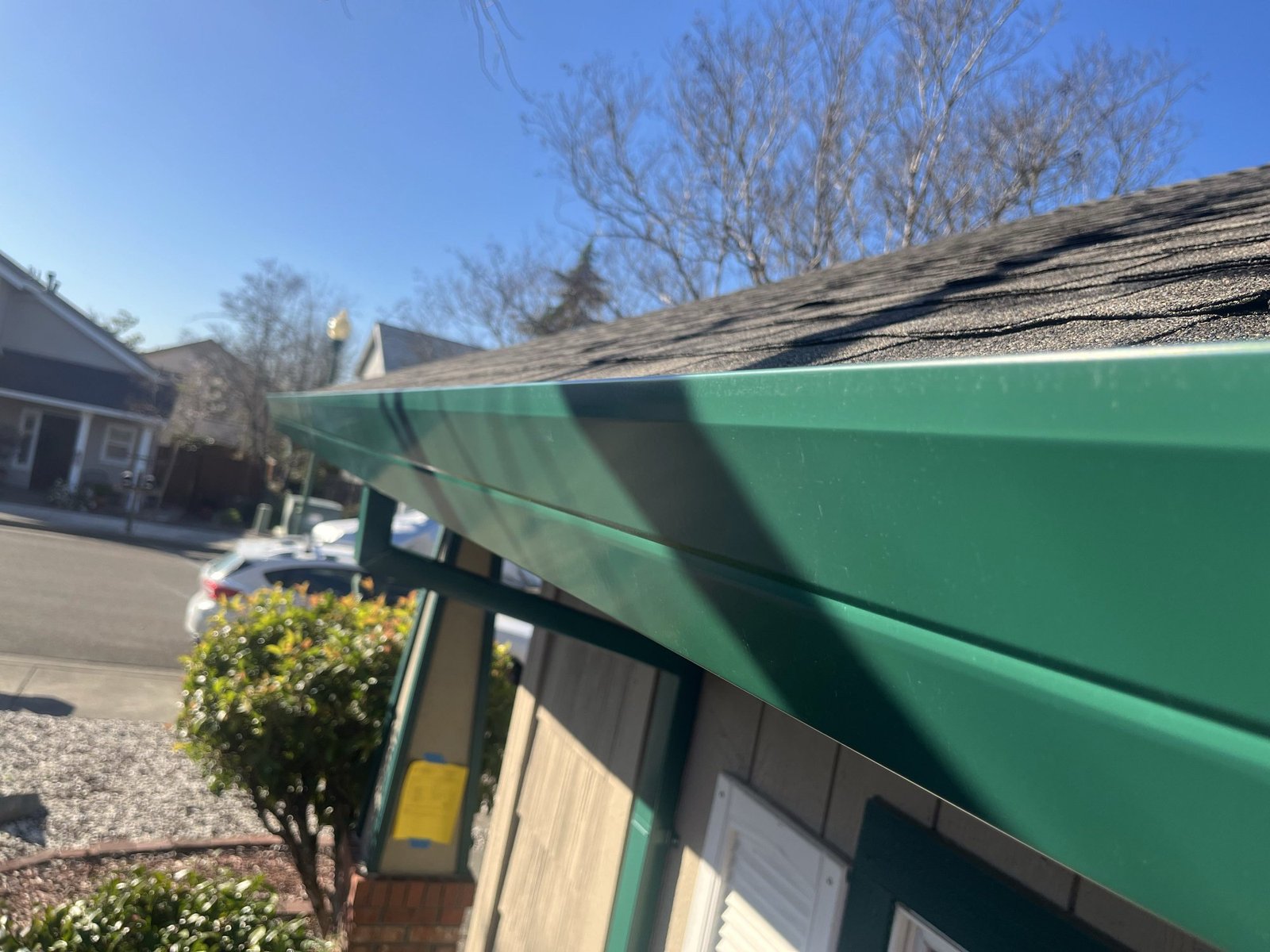 Residential roofline from street level — gutters barely visible, well-maintained Northern California home